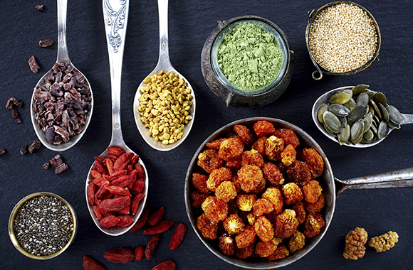 Various superfoods on black background